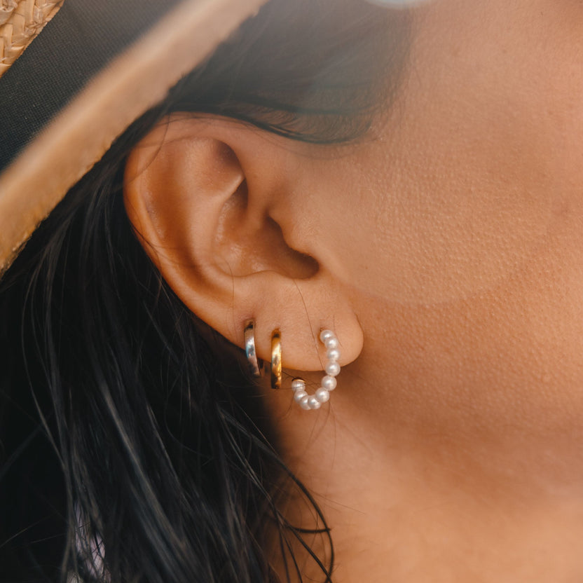 Nickelfreie Creolen mit Muscheldetails, getragen am Ohr, von PURELEI.