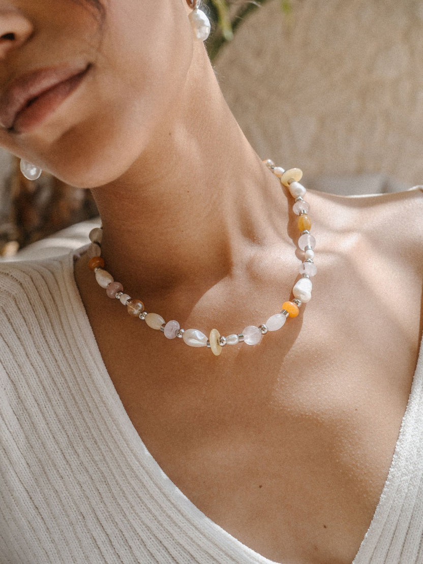 Perlenkette mit Muscheldetails, getragen in warmem Licht, von PURELEI.