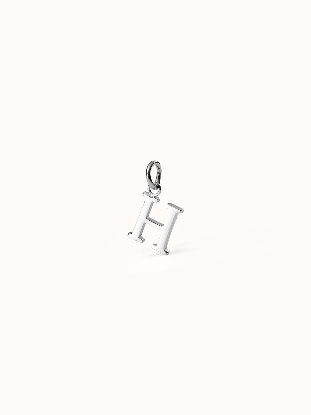 Purelei Pure H Charm aus nickelfreiem, silbernem Edelstahl, klar und elegant, minimalistisch auf hellem Hintergrund.