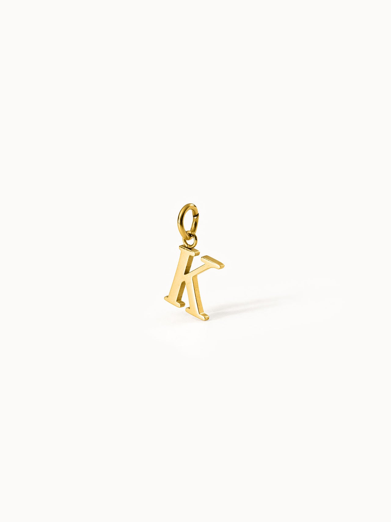 PURELEI Pure K Charm in 18K Gold mit klarer Letter-Form, elegant und zeitlos vor hellem Hintergrund präsentiert.