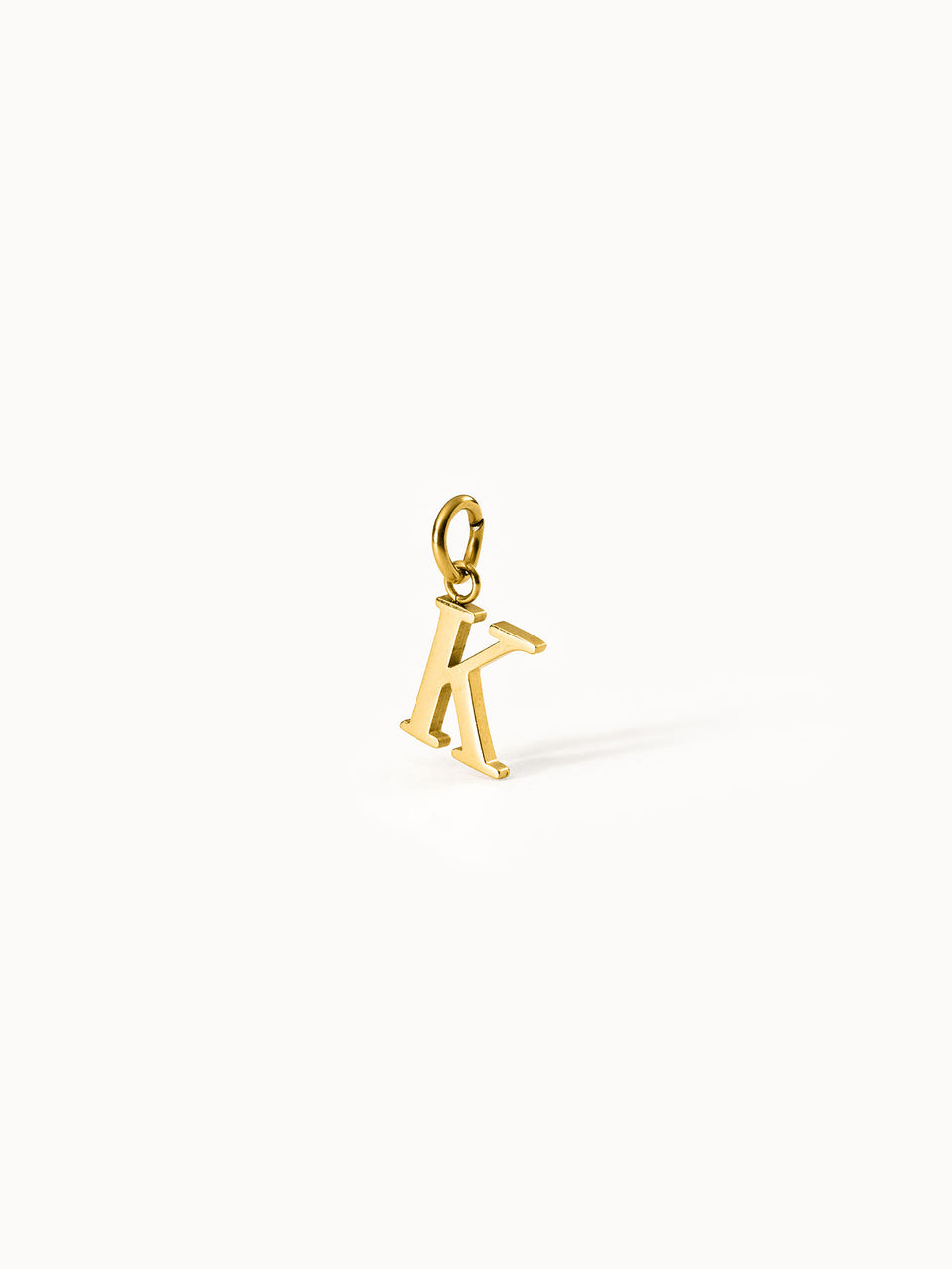 PURELEI Pure K Charm in 18K Gold mit klarer Letter-Form, elegant und zeitlos vor hellem Hintergrund präsentiert.