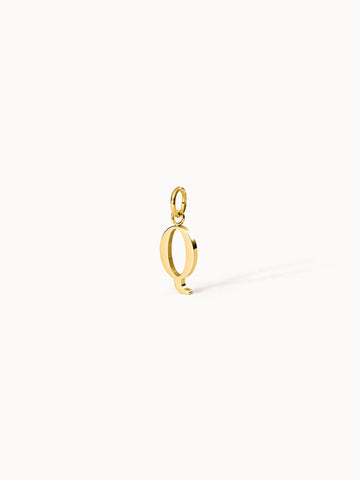 Purelei Pure Q Charm aus goldfarbenem Edelstahl, eleganter Buchstabenanhänger mit klarem Design vor hellen Hintergrund.