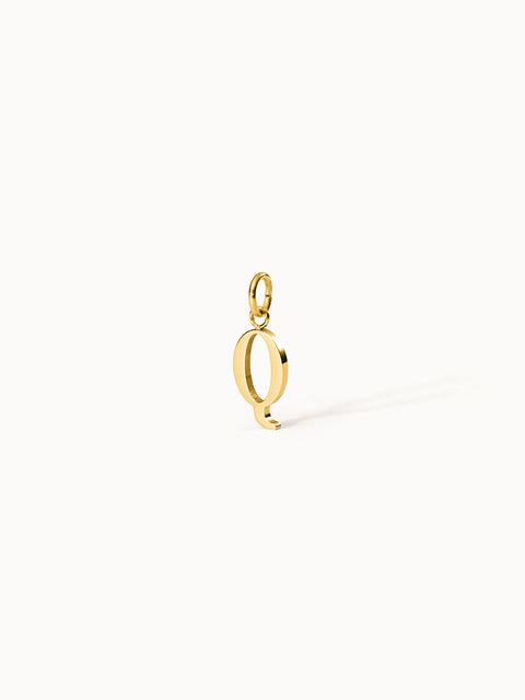 Purelei Pure Q Charm aus goldfarbenem Edelstahl, eleganter Buchstabenanhänger mit klarem Design vor hellen Hintergrund.