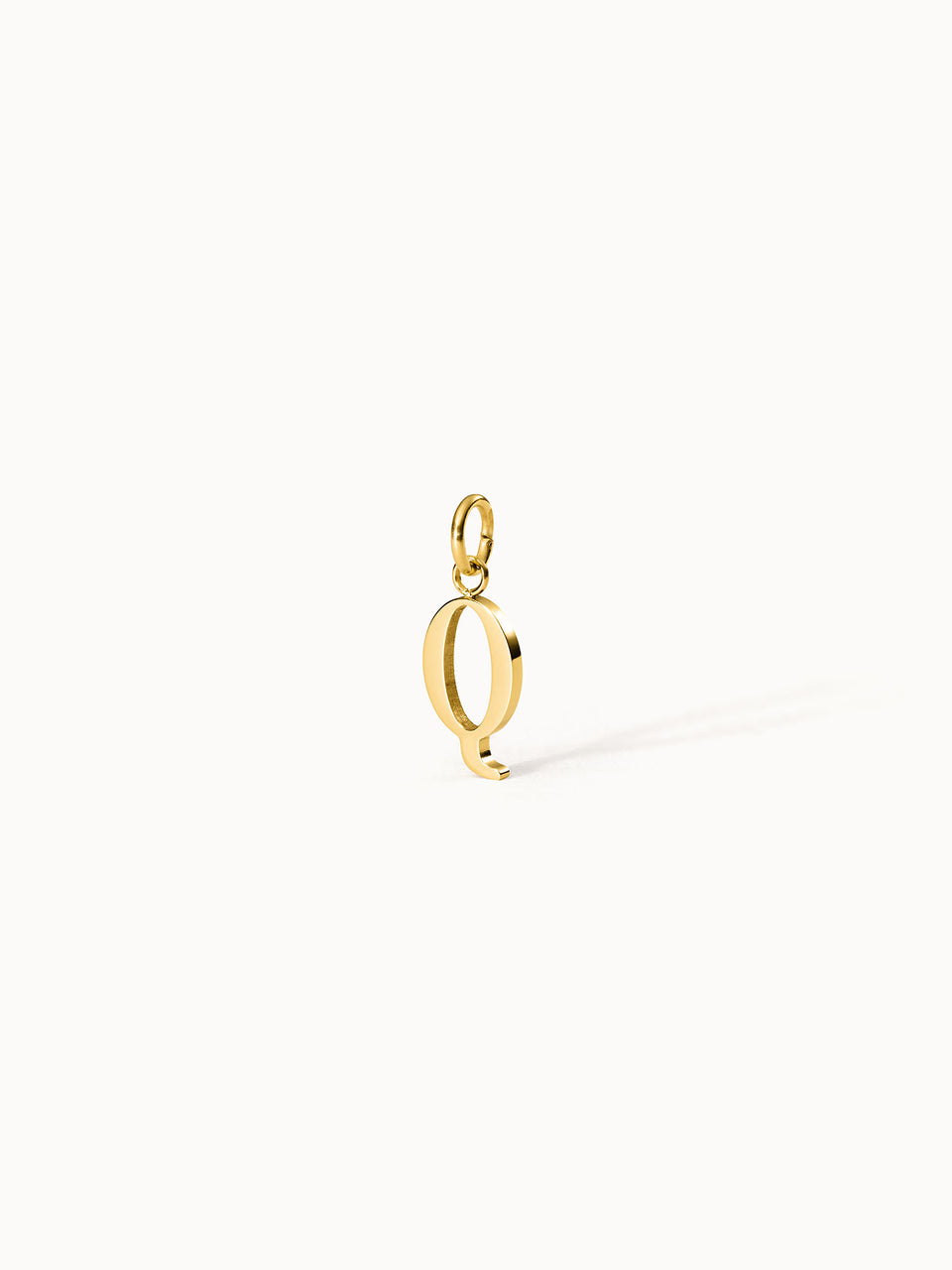 Purelei Pure Q Charm aus goldfarbenem Edelstahl, eleganter Buchstabenanhänger mit klarem Design vor hellen Hintergrund.