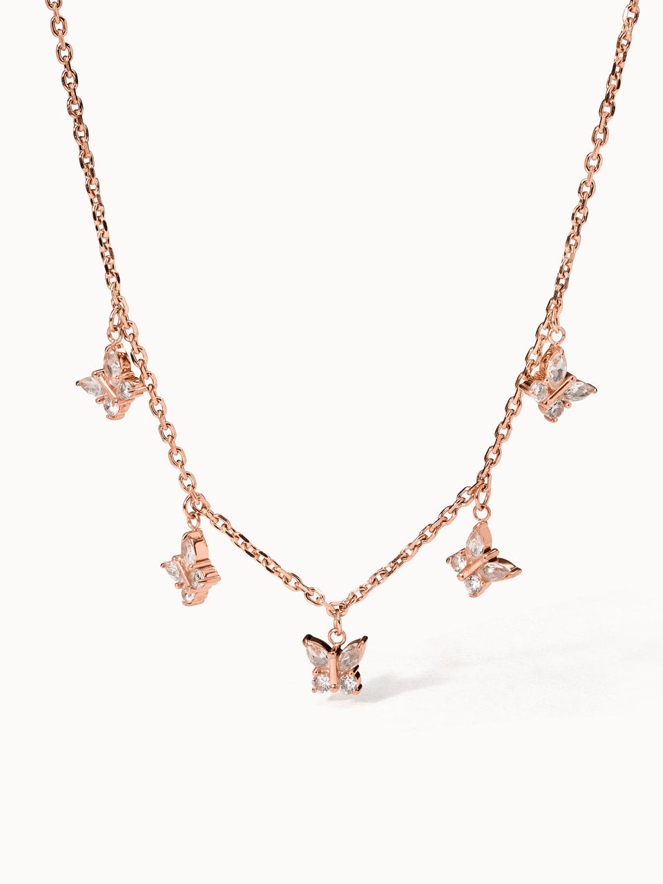 Roségoldene Kette mit Schmetterlings-Anhängern von PURELEI, elegant und verspielt.