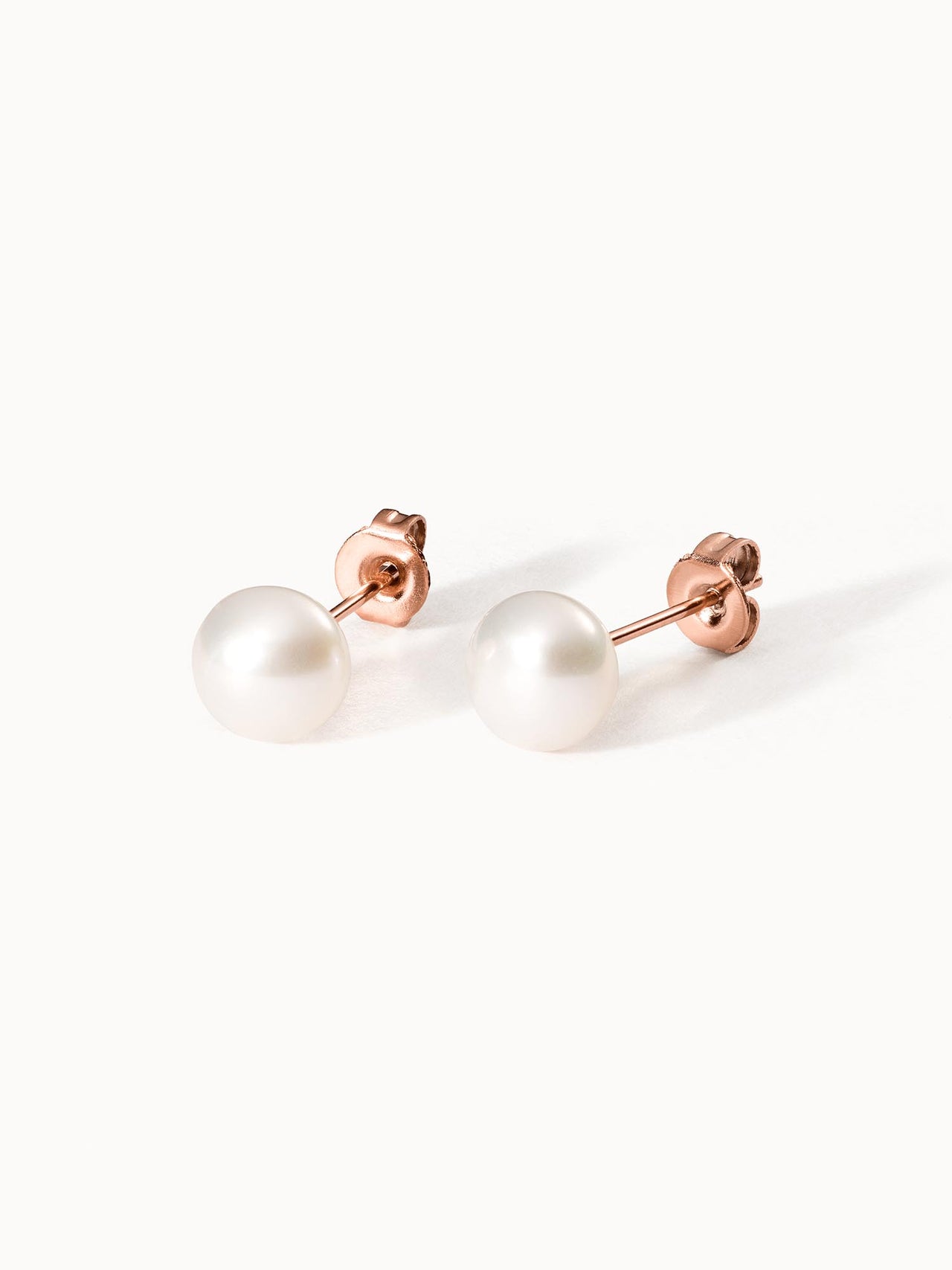 Roségoldene Ohrstecker mit weißen Perlen von PURELEI, elegant und feminin.