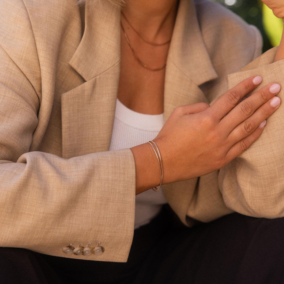 Silbernes Armband von PURELEI am Handgelenk, elegant und modern, getragen mit Blazer.