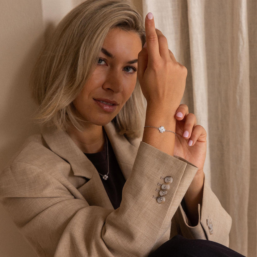 Silbernes Armband mit floralem Design, getragen von einer Frau in eleganter Kleidung – PURELEI.