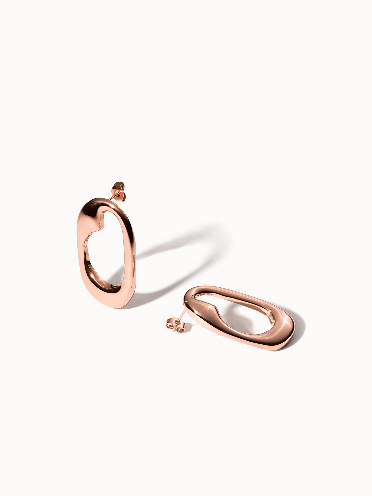 Roségoldene Creolen mit geschwungenem Design von PURELEI, elegant und modern.