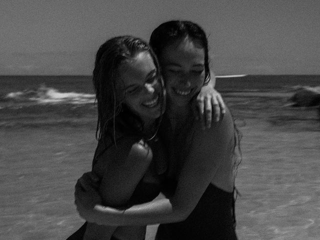 Zwei Frauen am Strand umarmen sich, pure Freude und Aloha-Spirit mit PURELEI.