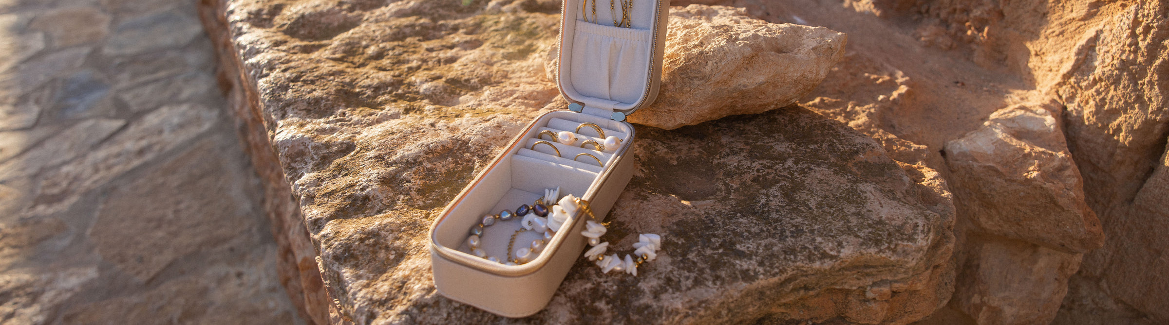 PURELEI Schmuckbox mit eleganten Accessoires auf Stein, warmes Licht und natürliche Ästhetik.