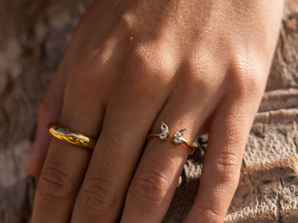 Roségoldener Ring mit funkelnden Steinen, getragen auf einer Hand, von PURELEI.