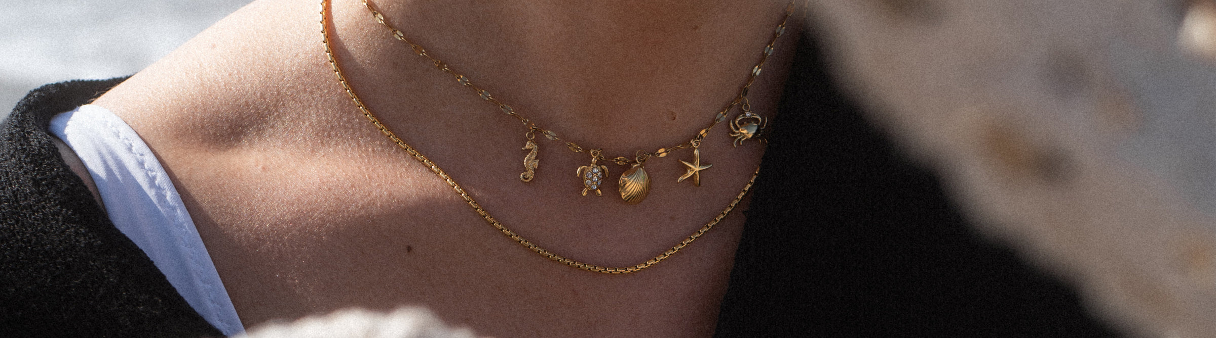Roségoldene Kette mit maritimen Anhängern, getragen am Hals, von PURELEI.