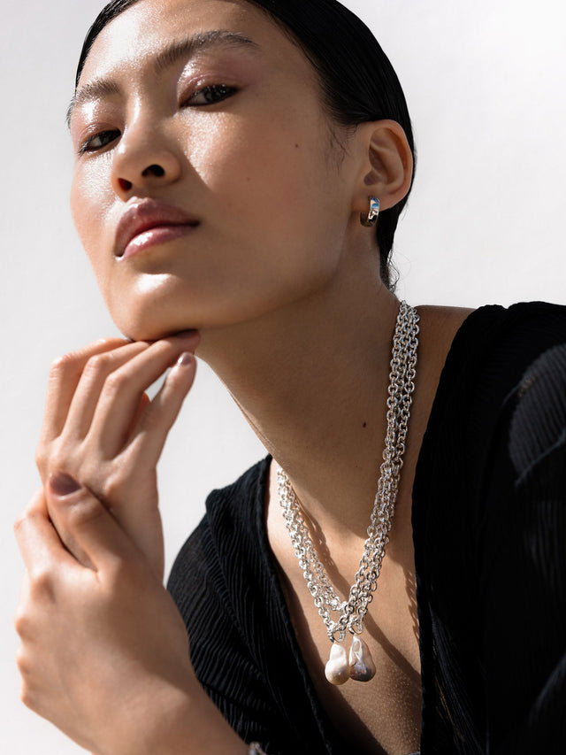 Silberne Kette mit Anhängern, elegant getragen, PURELEI inspiriert von femininer Ästhetik.