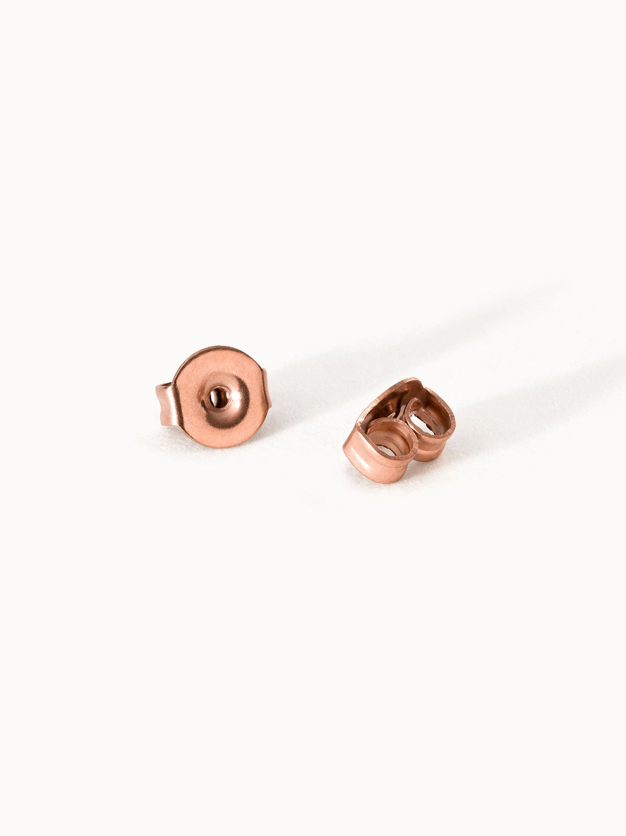 Ohrring Steckverschlüsse aus 18K rosévergoldetem Edelstahl, elegant schlicht auf hellem Hintergrund, PURELEI.