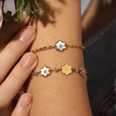 Roségoldenes Armband mit blütenförmigen Anhängern, getragen am Handgelenk, von PURELEI.