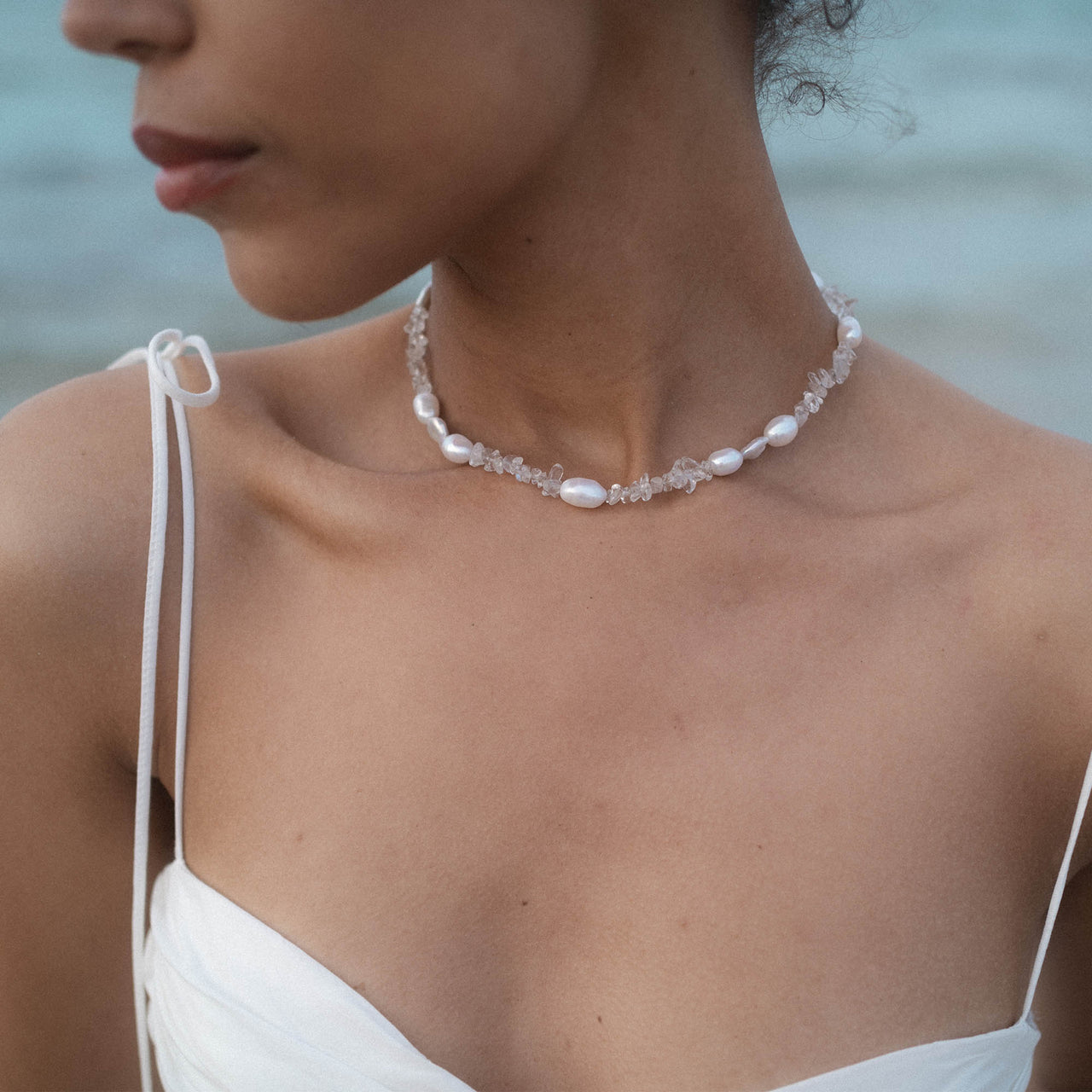 PURELEI Crystal Wave Kette mit schimmernden Keshi-Perlen und Bergkristall, elegant und feminin am Hals getragen.