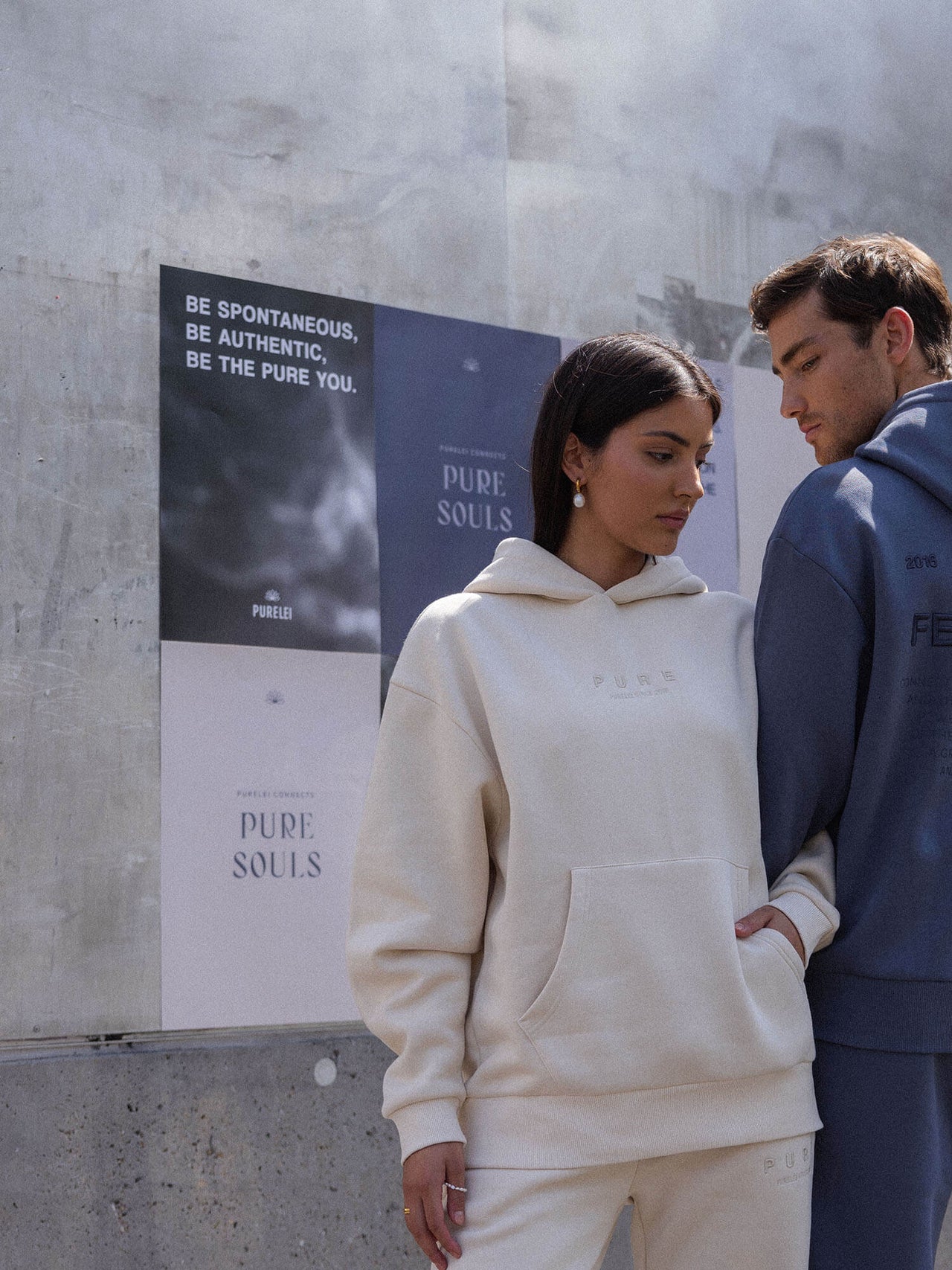 Beige Kapuzenpullover von PURELEI, lässig und modern, umgeben von urbanem Flair.