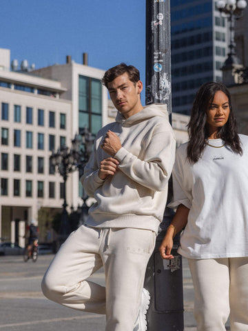 Beige PURELEI Streetwear-Outfit, lässig und modern, vor urbanem Hintergrund.