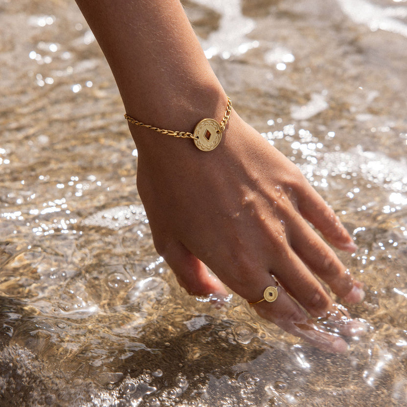 Roségoldenes Armband mit ovalem Anhänger, getragen im Wasser – PURELEI.