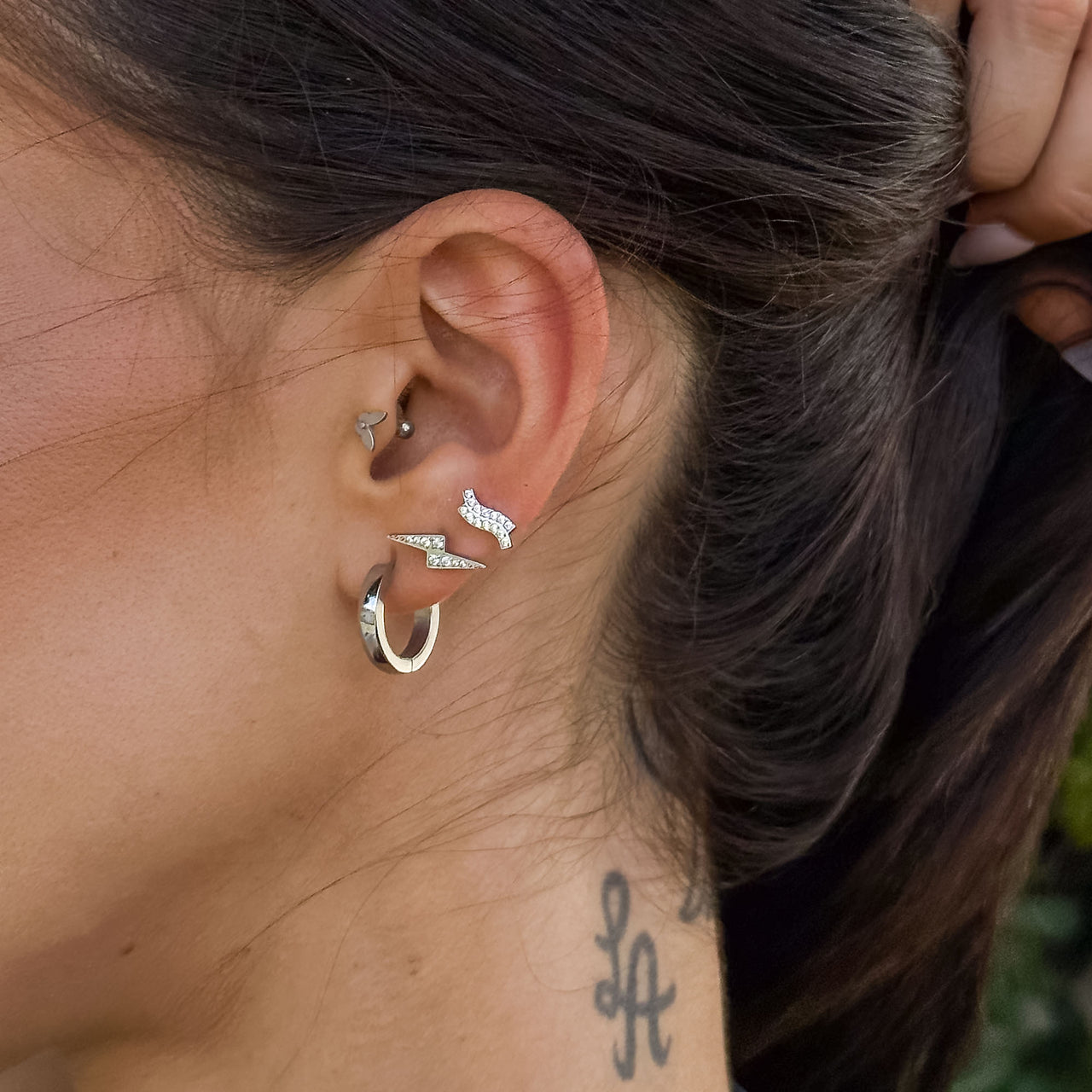Roségoldene Ohrringe mit wellenförmigem Design, getragen in elegantem Styling, PURELEI.