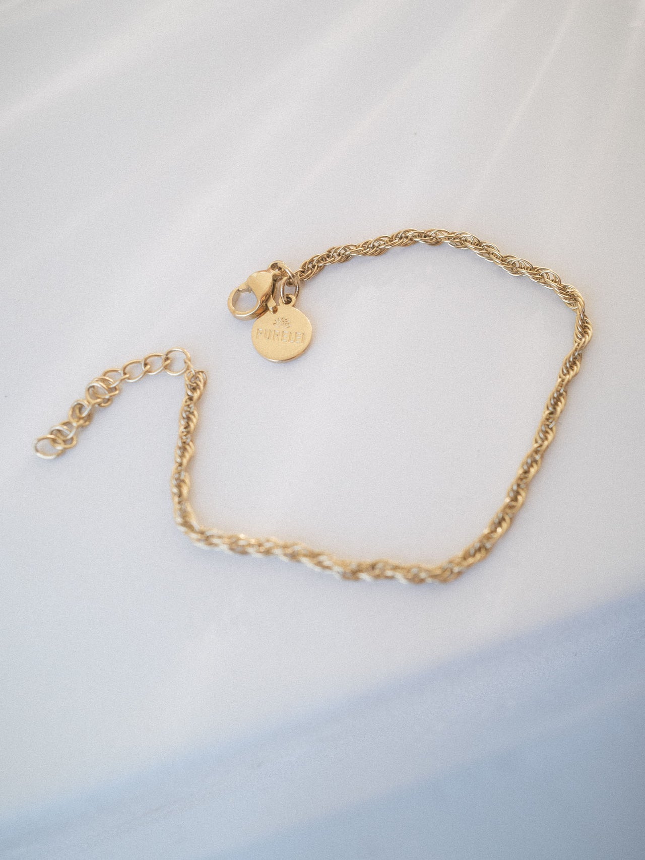 Feines goldfarbenes, gedrehtes Vintage Armband von PURELEI auf hellem Hintergrund, elegant und minimalistisch.