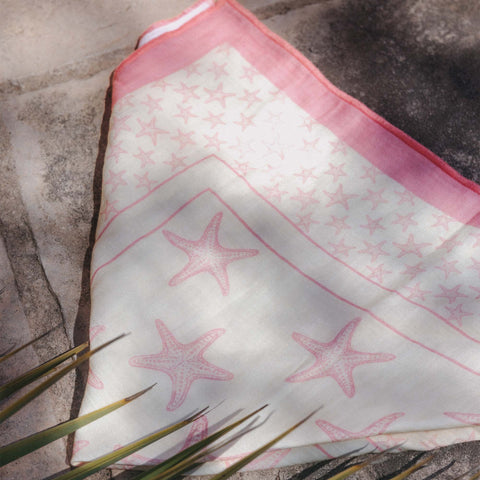 Zarte, rosa-weiße Tuch mit Sternenmotiv von PURELEI auf Steinuntergrund.