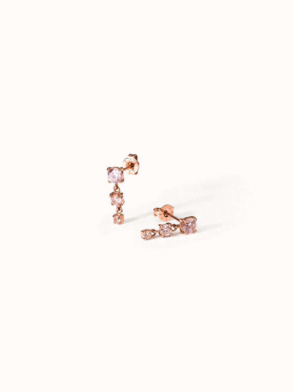 Roségoldene Ohrringe mit funkelnden Steinen von PURELEI, elegant und feminin.