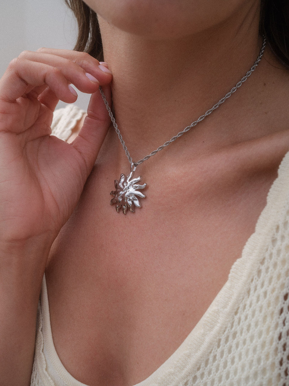 Iconic Sun Charm Halsschmuck aus silberfarbenem Edelstahl, sonneninspiriertes Design, getragen für pure Eleganz von PURELEI.