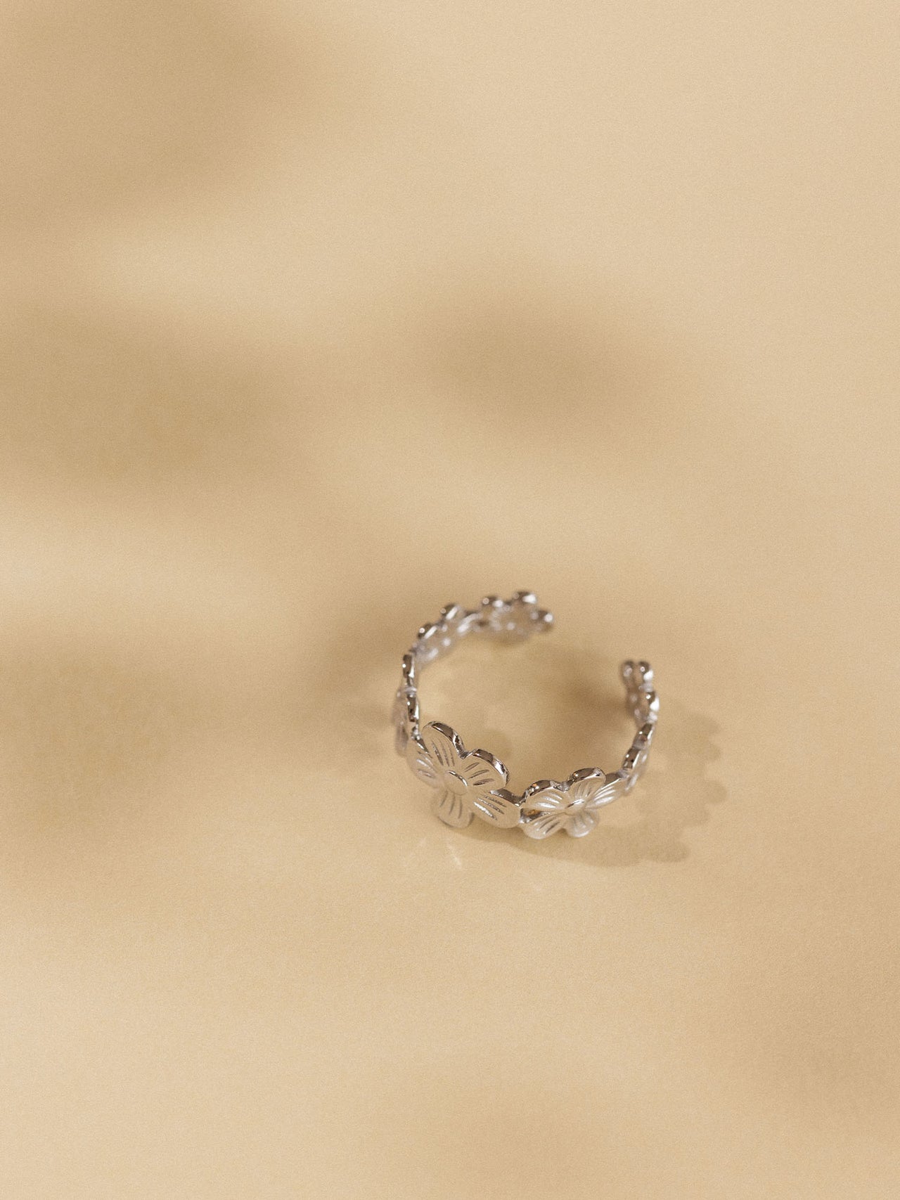 Goldener Ring mit floralen Details auf sanftem Hintergrund, PURELEI inspiriert.