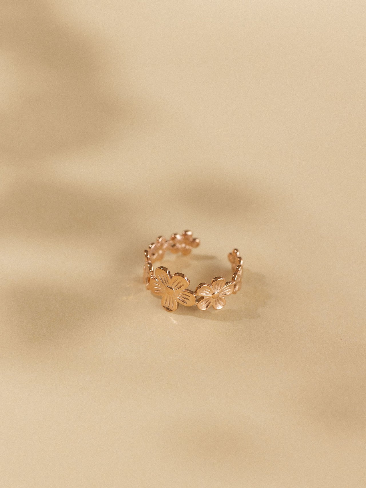 Goldenes Blumenring-Design von PURELEI, elegant und feminin, auf sanftem Hintergrund.