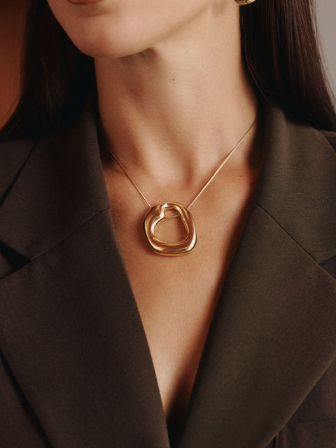 Roségoldene Kette mit organischem Anhänger, getragen in elegantem Outfit von PURELEI.