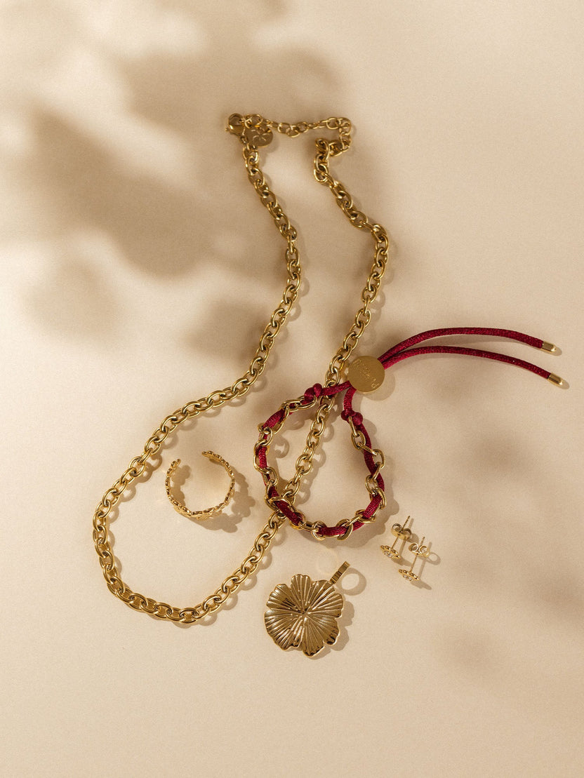 Goldene Kette, Armband und Ohrringe von PURELEI, inspiriert von tropischer Eleganz.