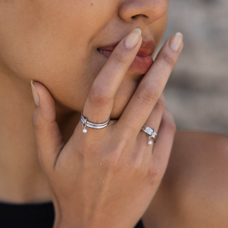 Silberne Ringe mit zarten Details, getragen an einer Hand, PURELEI inspiriert.