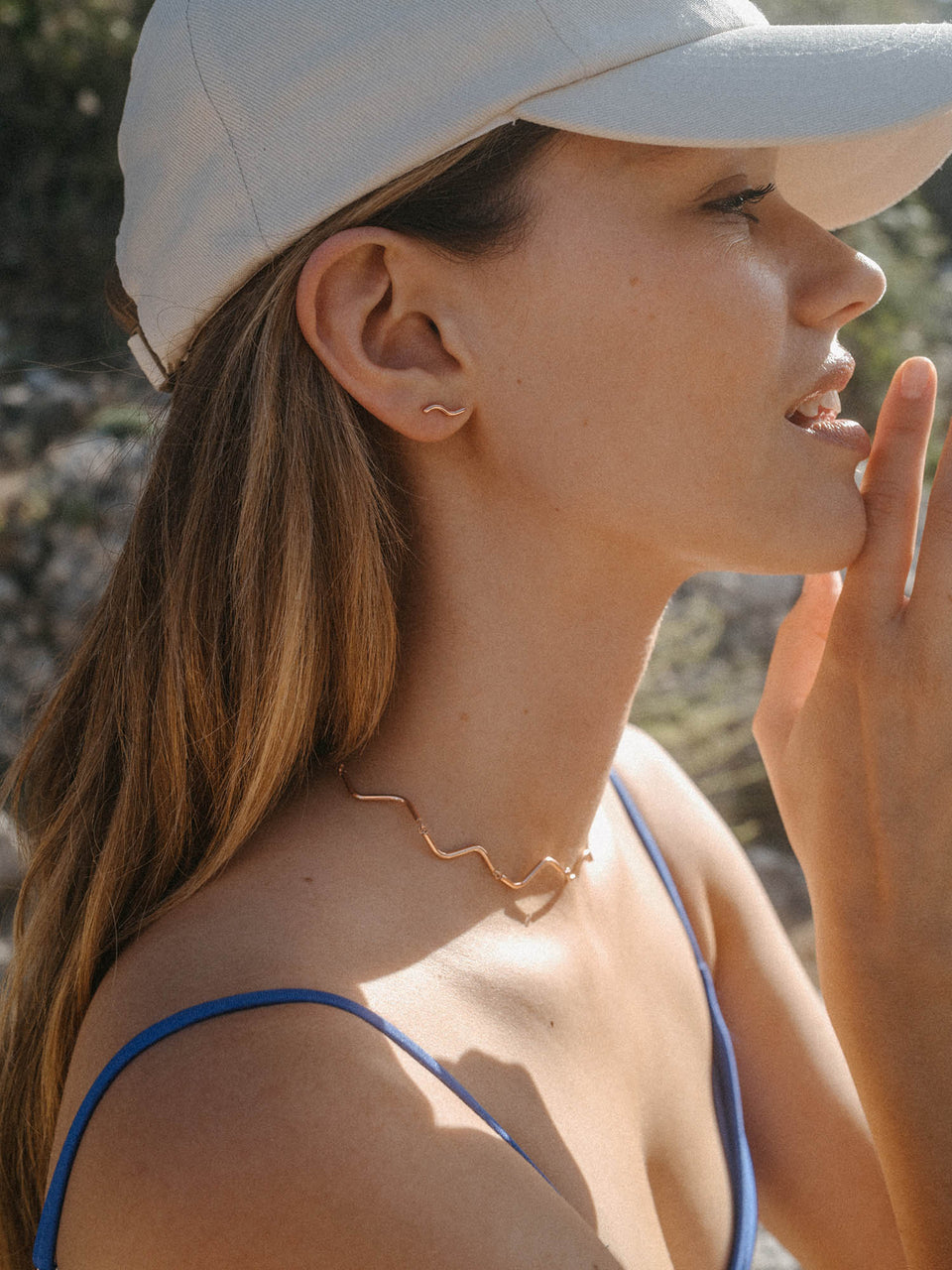 Roségoldenes Wellenhalsband von PURELEI, elegant und feminin, getragen im Sonnenlicht.