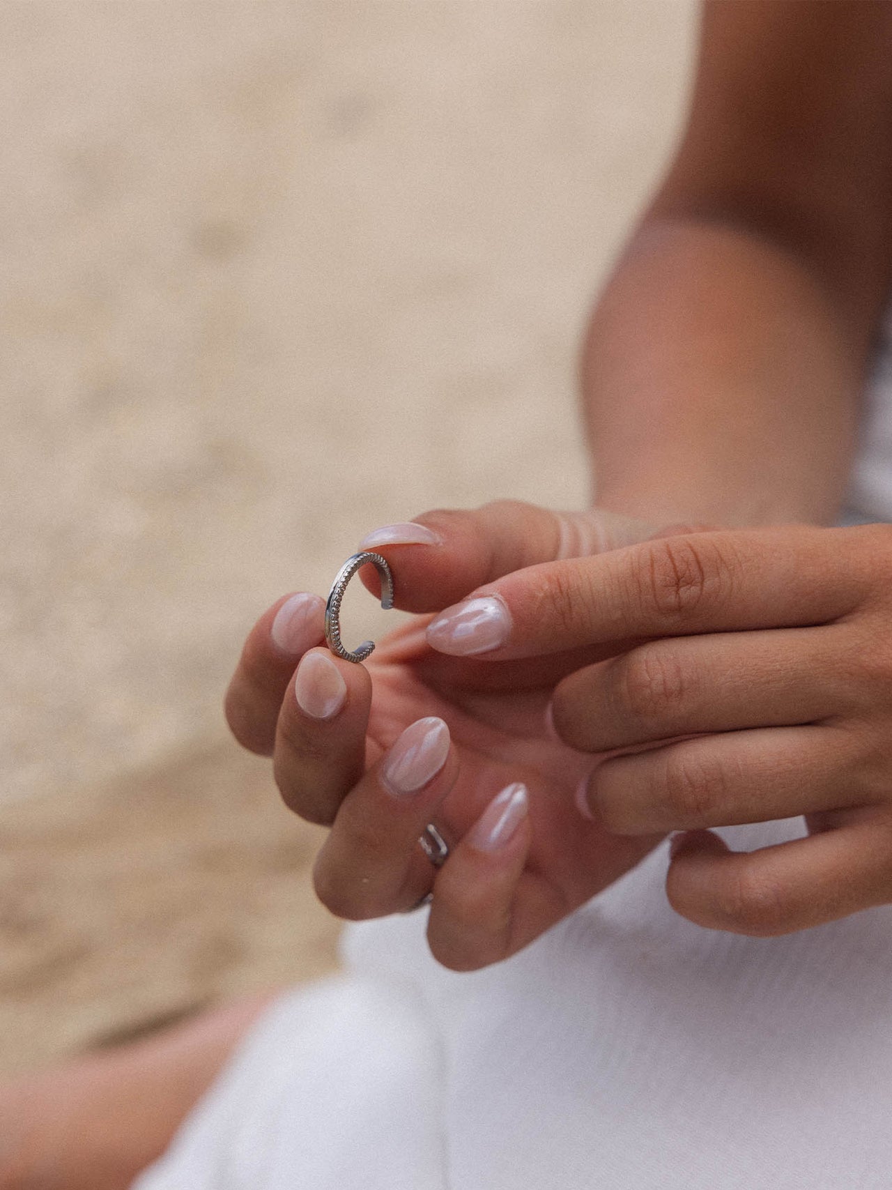 Silberner Ring in zarten Händen, PURELEI, elegant und feminin.