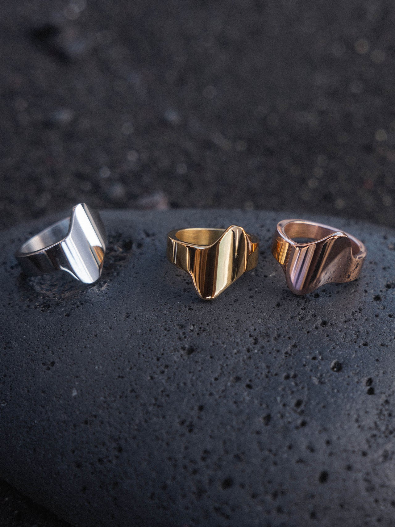 Lava Ring in Silber, Gold und Roségold, geschwungene Edelstahlringe auf schwarzem Lavastein von PURELEI.