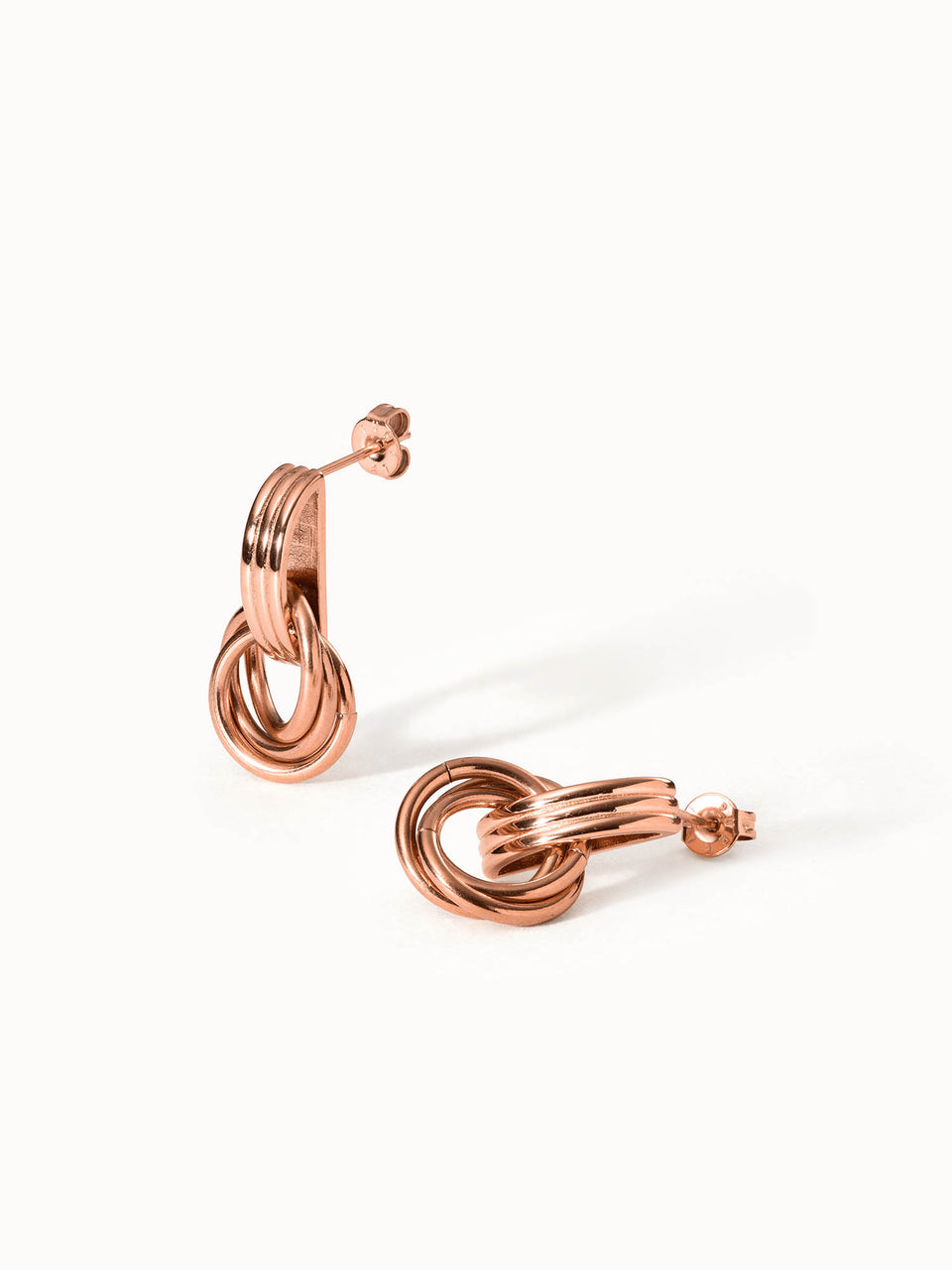 PURELEI He Nui Ohrringe in Roségold, ineinander verschlungene Ringe, elegant und feminin, warmes Licht, edler Look