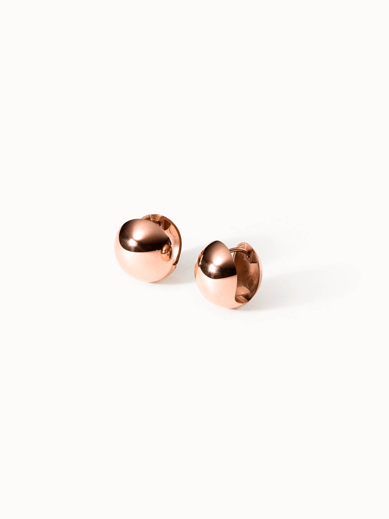 Roségoldene Creolen mit glänzender Oberfläche von PURELEI, elegant und modern.