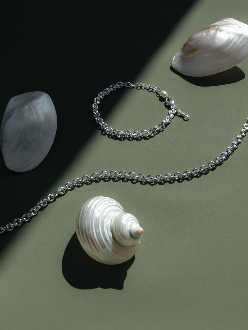 PURELEI Dream Kette aus recyceltem Silber mit schimmernder Süßwasserperle auf grünem Untergrund, elegant.