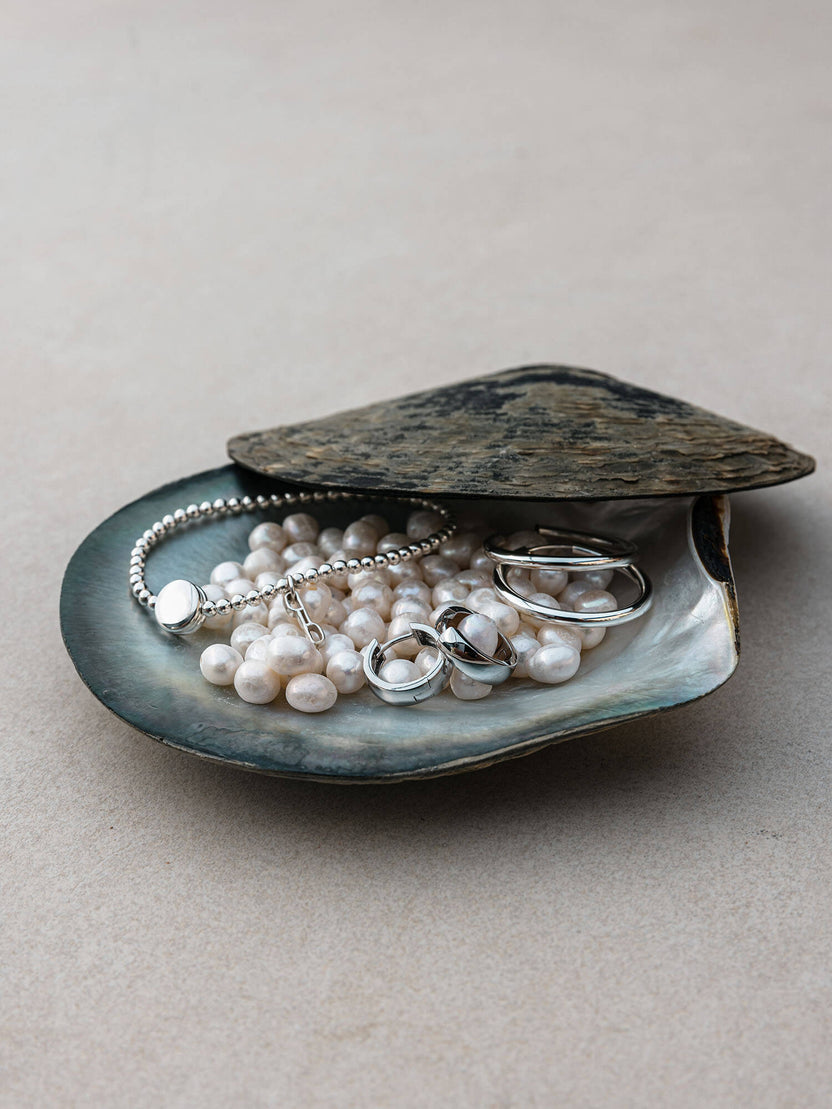 Essence Ohrringe aus recyceltem 925er Silber auf Muschelschale mit Perlen, PURELEI, elegant und feminin.