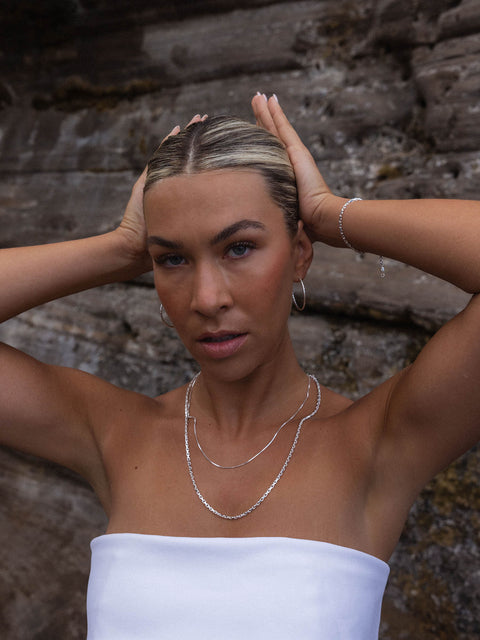 Perfection Kette aus recyceltem Silber mit schimmernder Süßwasserperle, getragen vor Felskulisse – PURELEI.