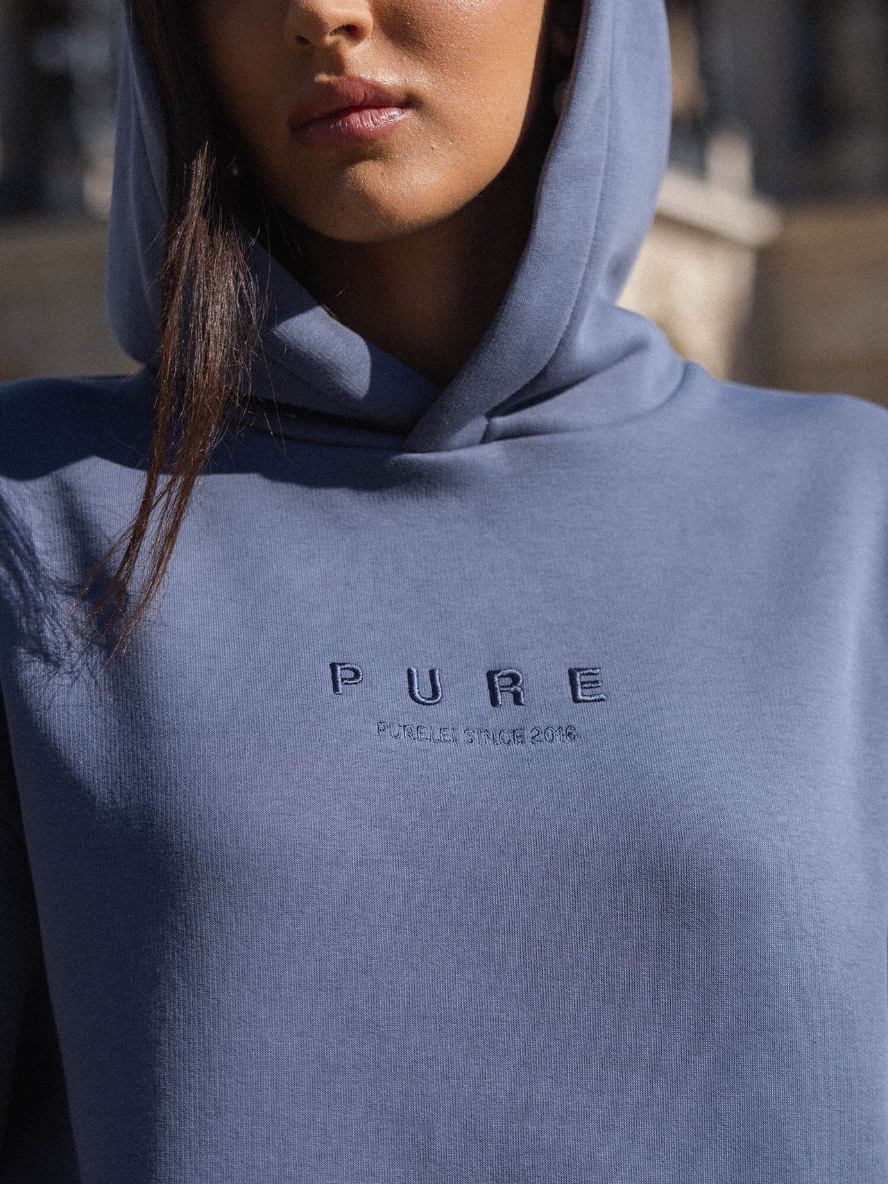 Blauer Hoodie mit gesticktem PURELEI Logo, lässig und modern.