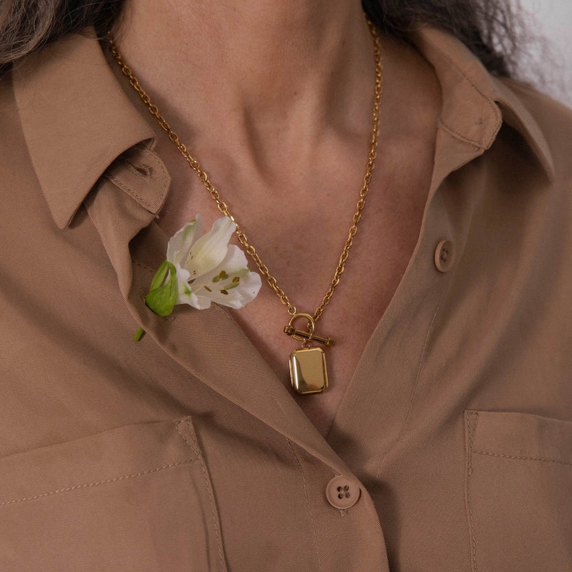 Roségoldene Kette mit Anhänger, getragen auf beigem Hemd, feminine Eleganz von PURELEI.