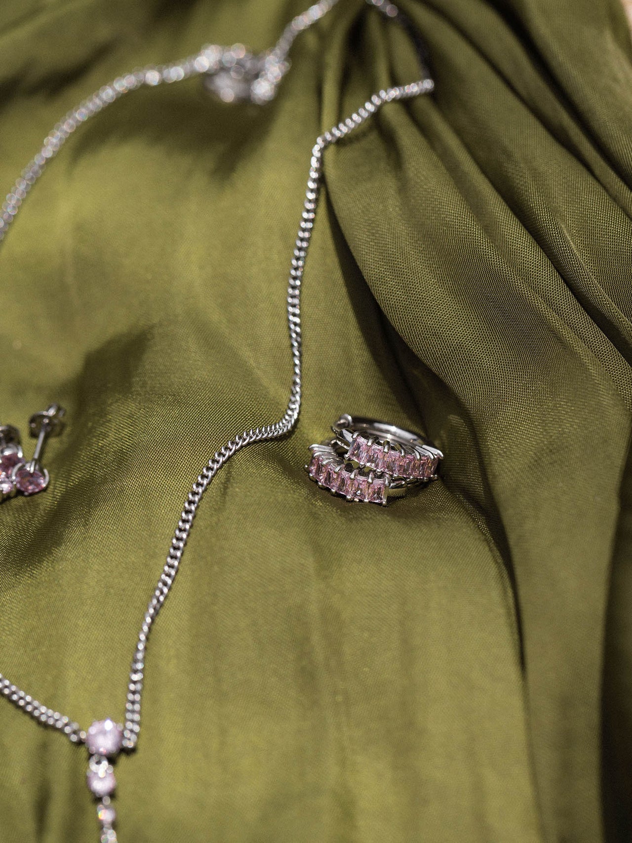 Silberne Kette und Ring auf grünem Stoff, elegant und zeitlos, von PURELEI.