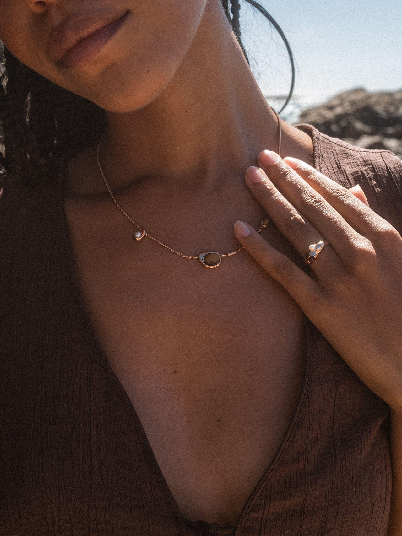 Goldene PURELEI Kette mit einzigartigem Design, getragen in warmem Licht.