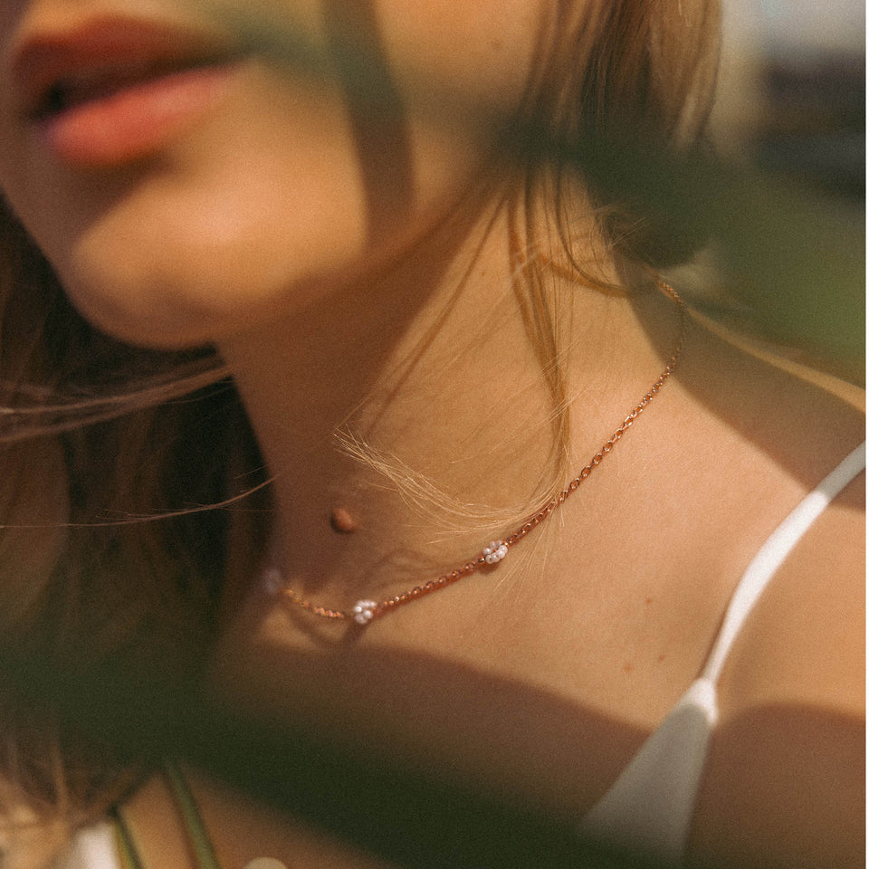 Zarte, roségoldene Kette mit Perlen, getragen in warmem Licht – PURELEI.