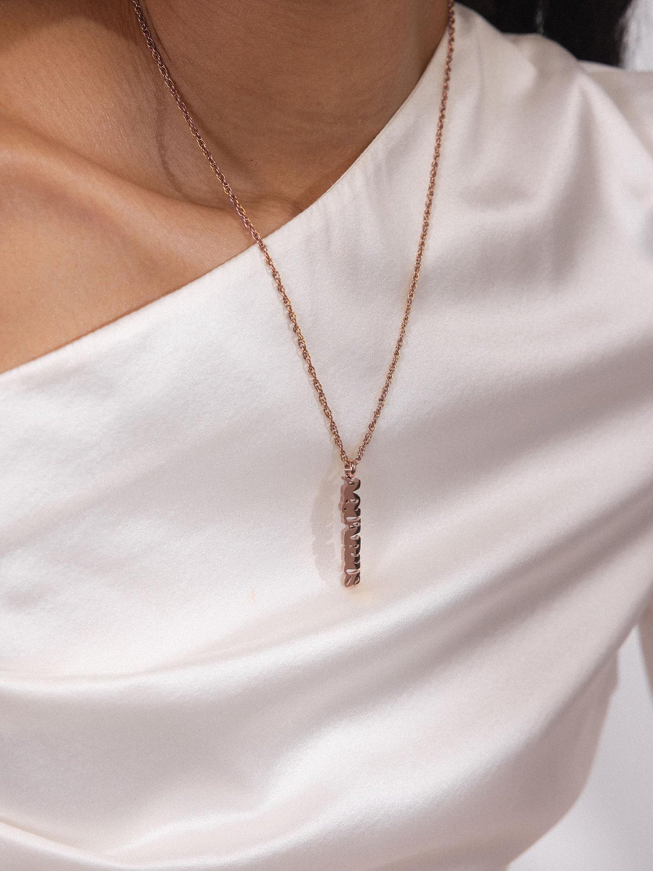 PURELEI Aquarius Letter Charm aus 18K Roségold, minimalistisches Design, elegant und feminin am Hals getragen.