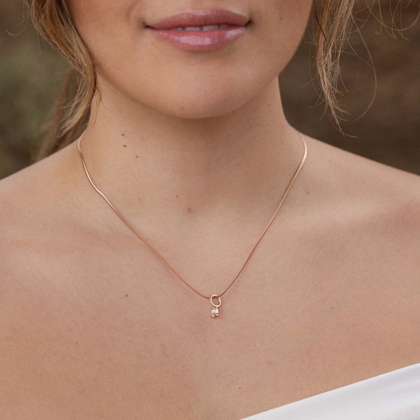 Zarte, roségoldene Kette mit Anhänger, getragen mit natürlichem Hintergrund – PURELEI.