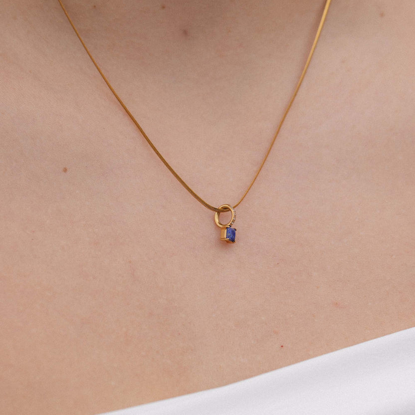 Goldene Kette mit Anhänger in Form eines Schlosses, getragen am Hals, von PURELEI.
